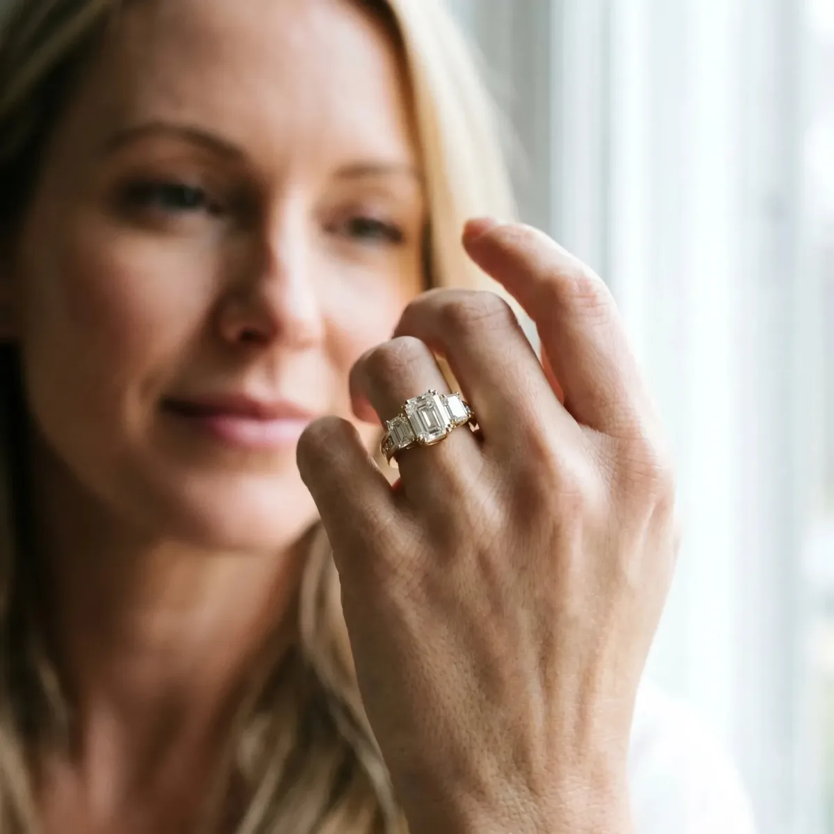 Three-Stone Emerald Cut Cut Diamond Ring with Channel Set Band and Four-Prong Setting Yellow gold