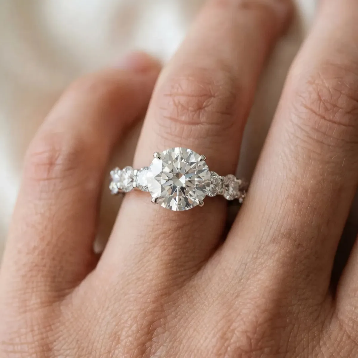 Round Cut Diamond Prong Setting with Side Stones on a Pave Band Platinum