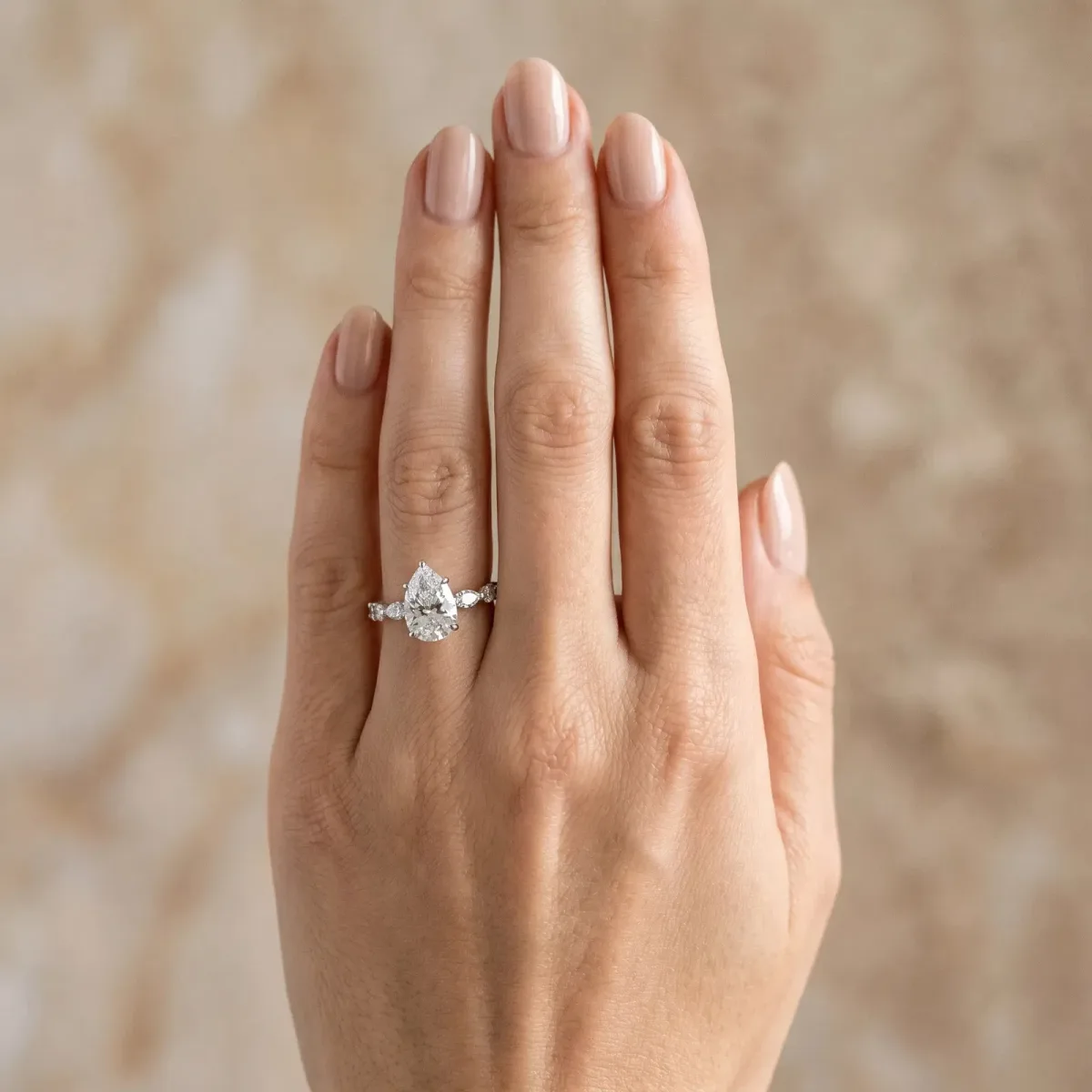Pear Cut Diamond Ring with Marquise and Round Side Stones and Four-Prong Setting Silver