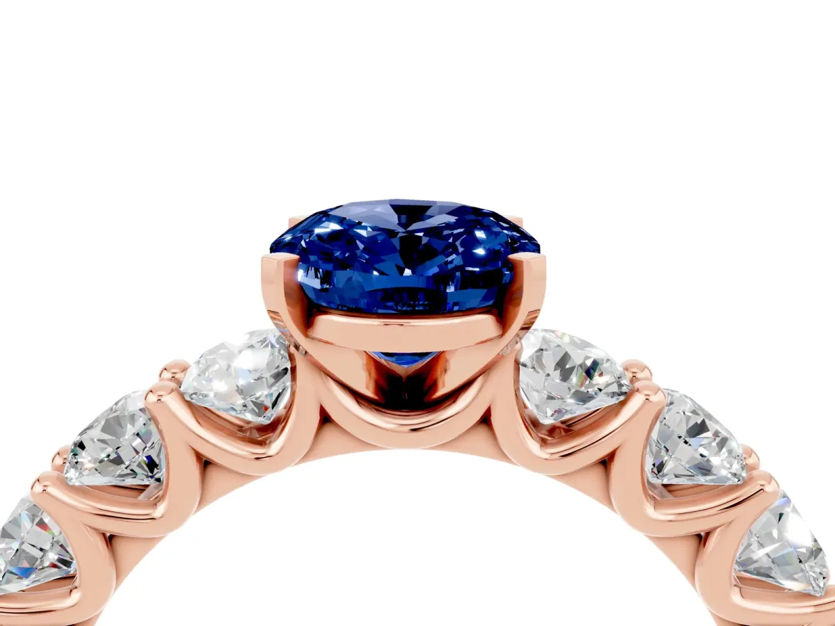 Oval Cut Blue Sapphire Prong Setting with Side Stones on a Pave Band Rose gold