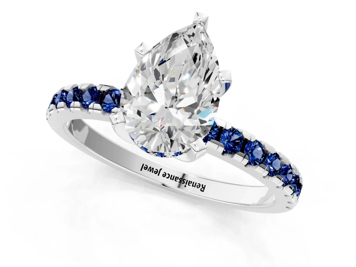 Pear Cut Diamond Solitaire Ring with Round Blue Sapphire Pavé Band and Four-Prong Setting Silver