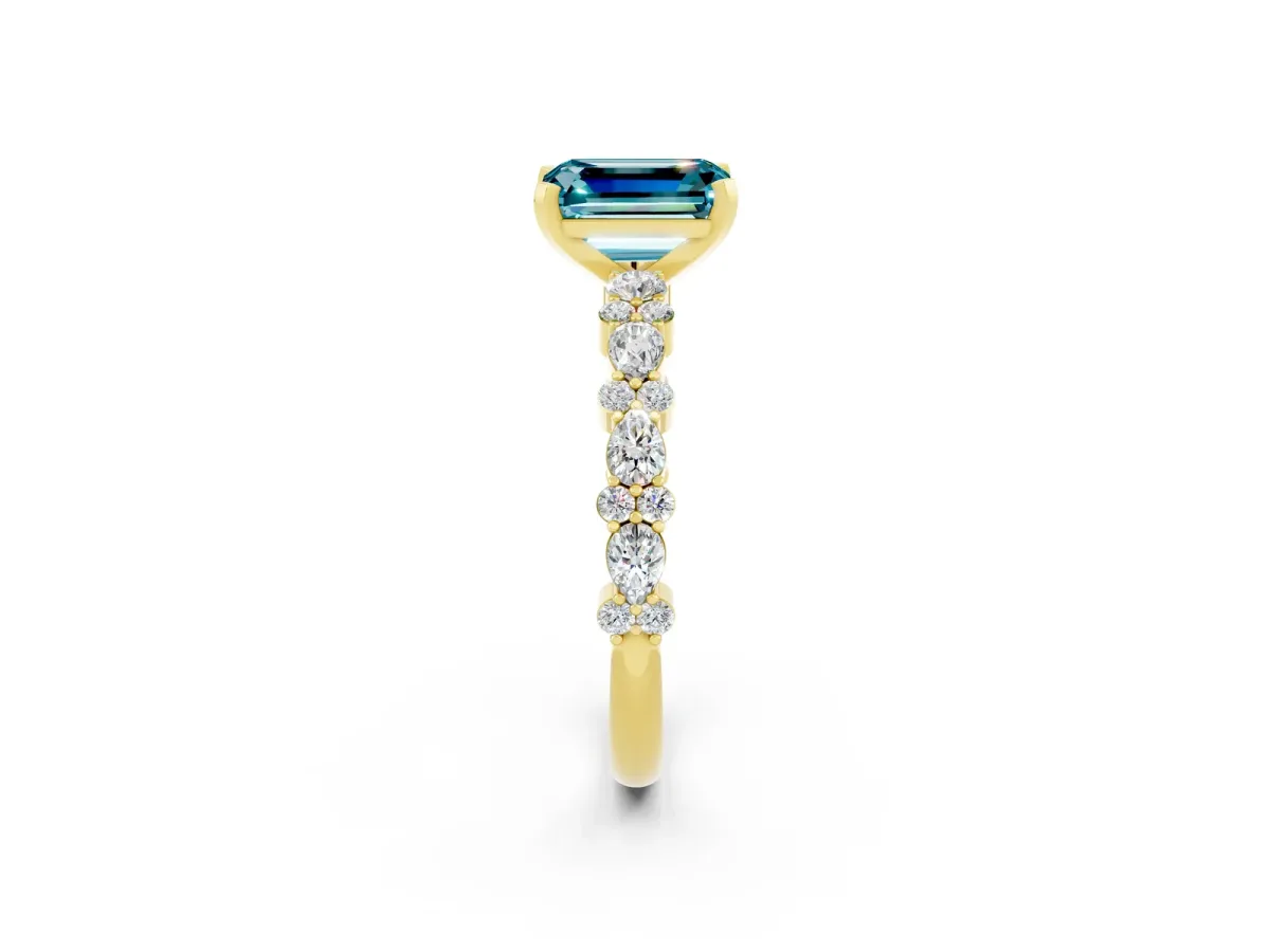 Emerald Cut Blue Topaz Side Stone Solitaire Ring with Round and Four-Prong Setting Yellow gold