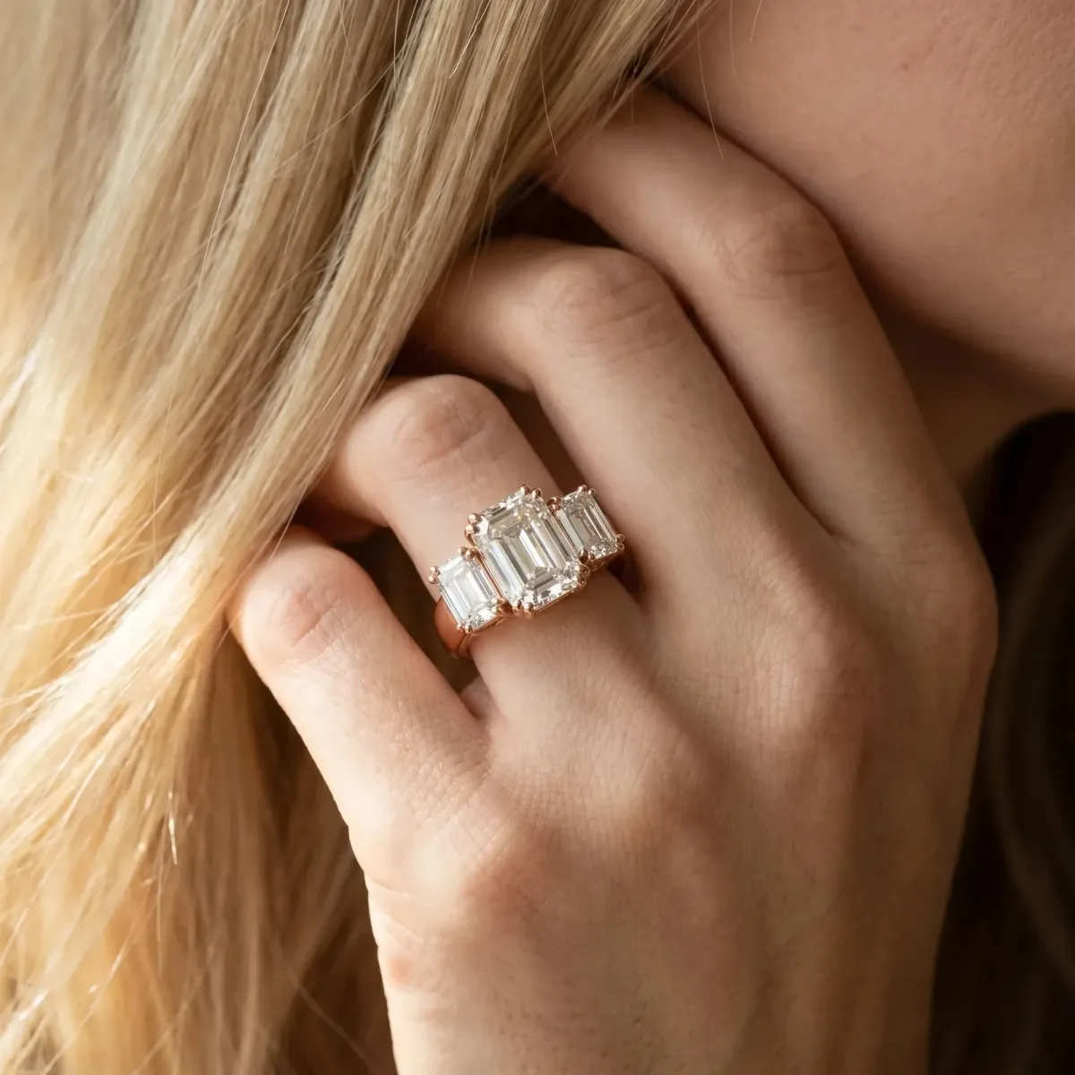 Three-Stone Emerald Cut Cut Diamond Ring with Channel Set Band and Four-Prong Setting Rose gold