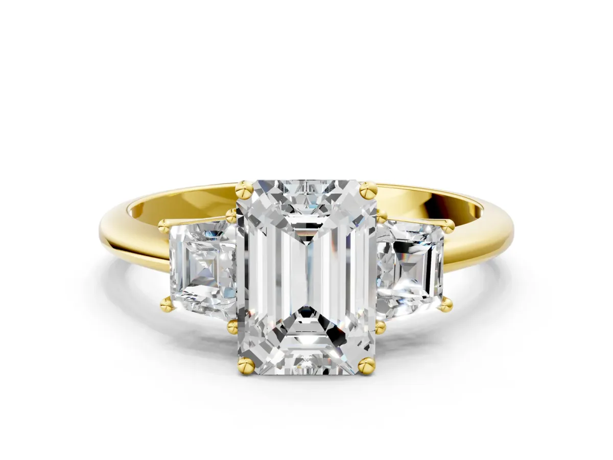Emerald Cut Diamond Three-Stone Ring with Trapezoid Side Stones and Prong Setting Yellow gold