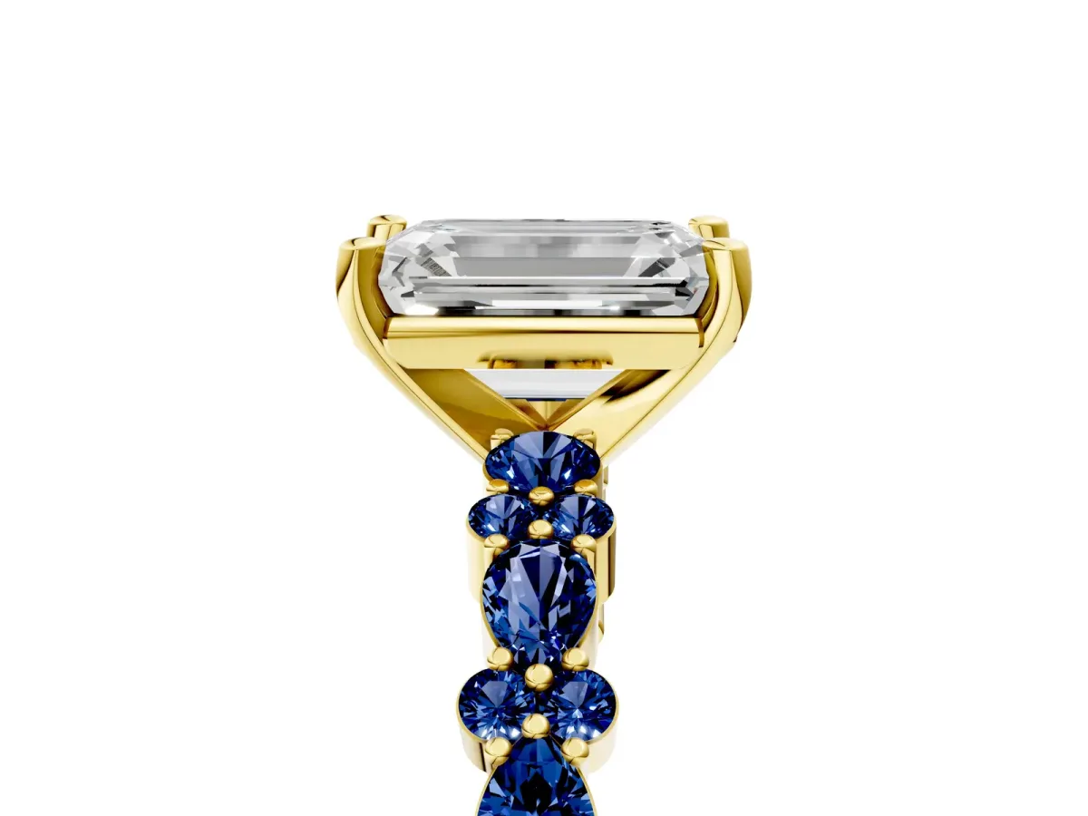 Emerald Cut Diamond Side Stone Solitaire Ring with Round Blue Sapphire and Four-Prong Setting Yellow gold