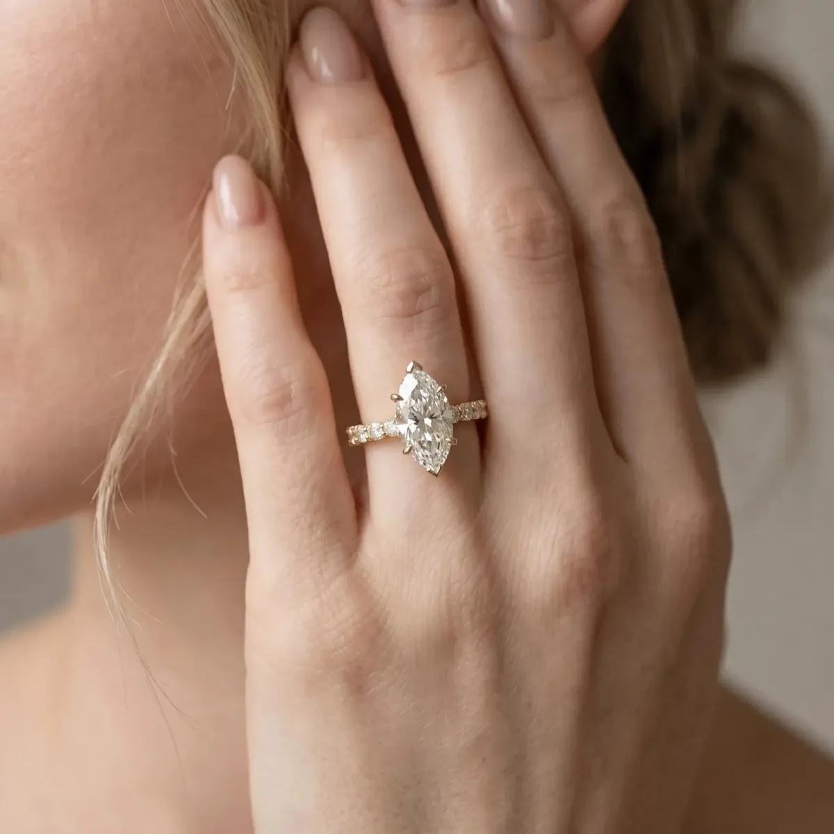 Marquise Cut Diamond Side Stone Solitaire Ring with Round and Four-Prong Setting Yellow gold