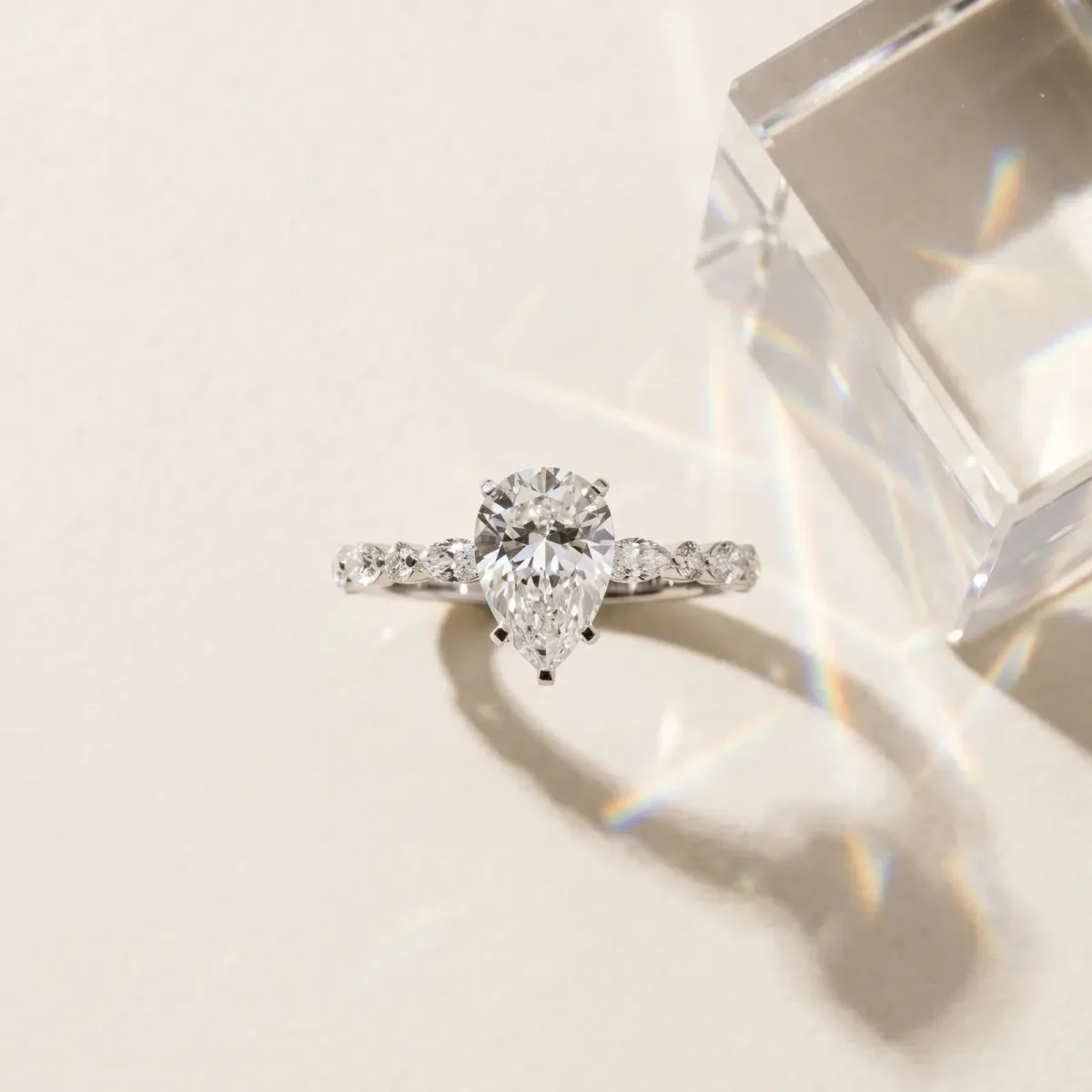 Pear Cut Diamond Ring with Marquise and Round Side Stones and Four-Prong Setting Silver