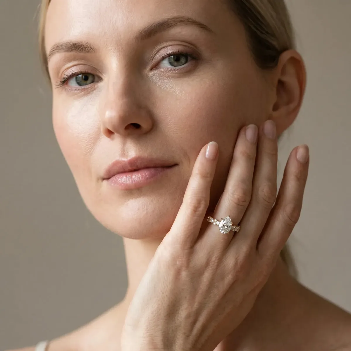 Pear Cut Diamond Side Stone Solitaire Ring with Round and Four-Prong Setting Yellow gold
