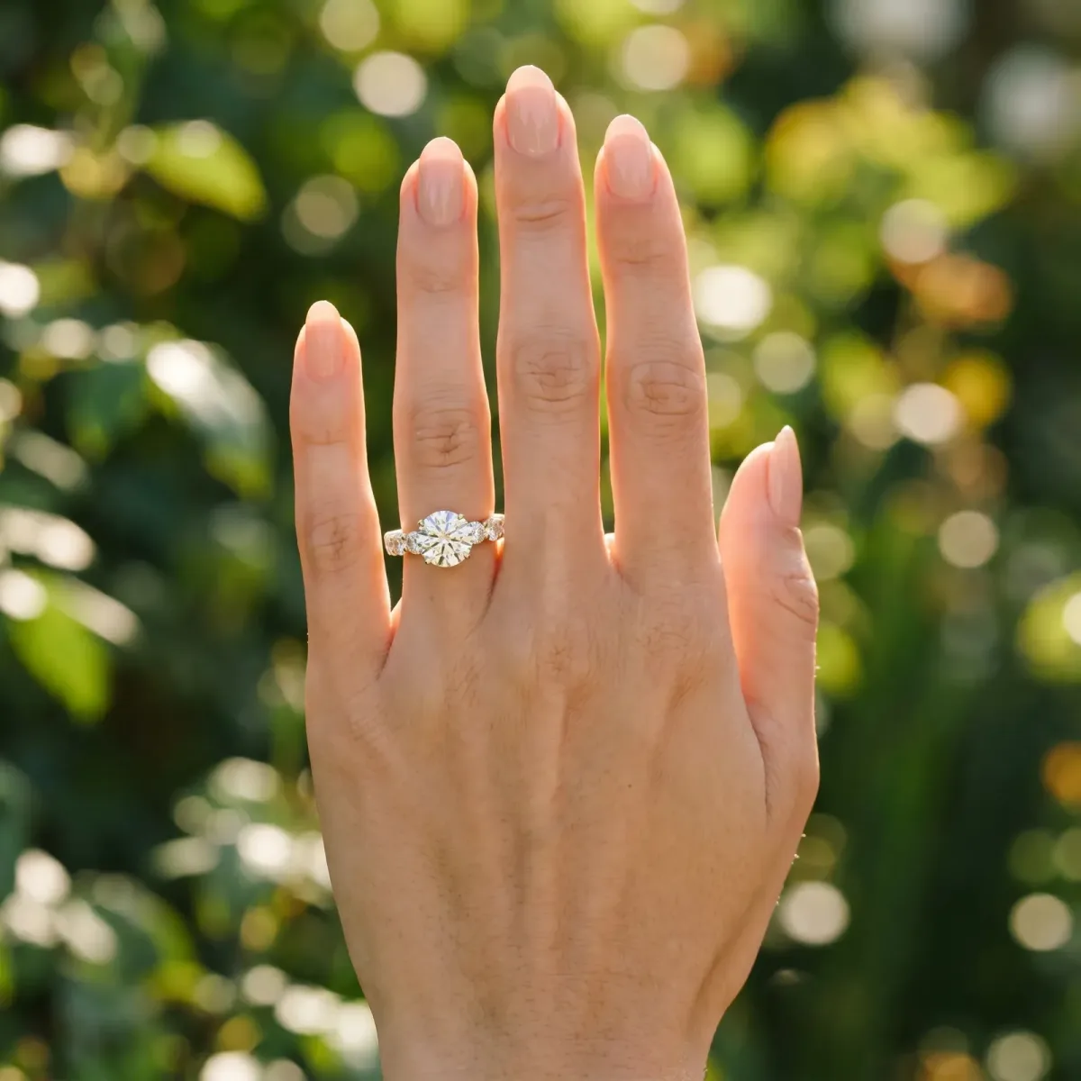 Round Cut Diamond Prong Setting with Side Stones on a Pave Band Yellow gold