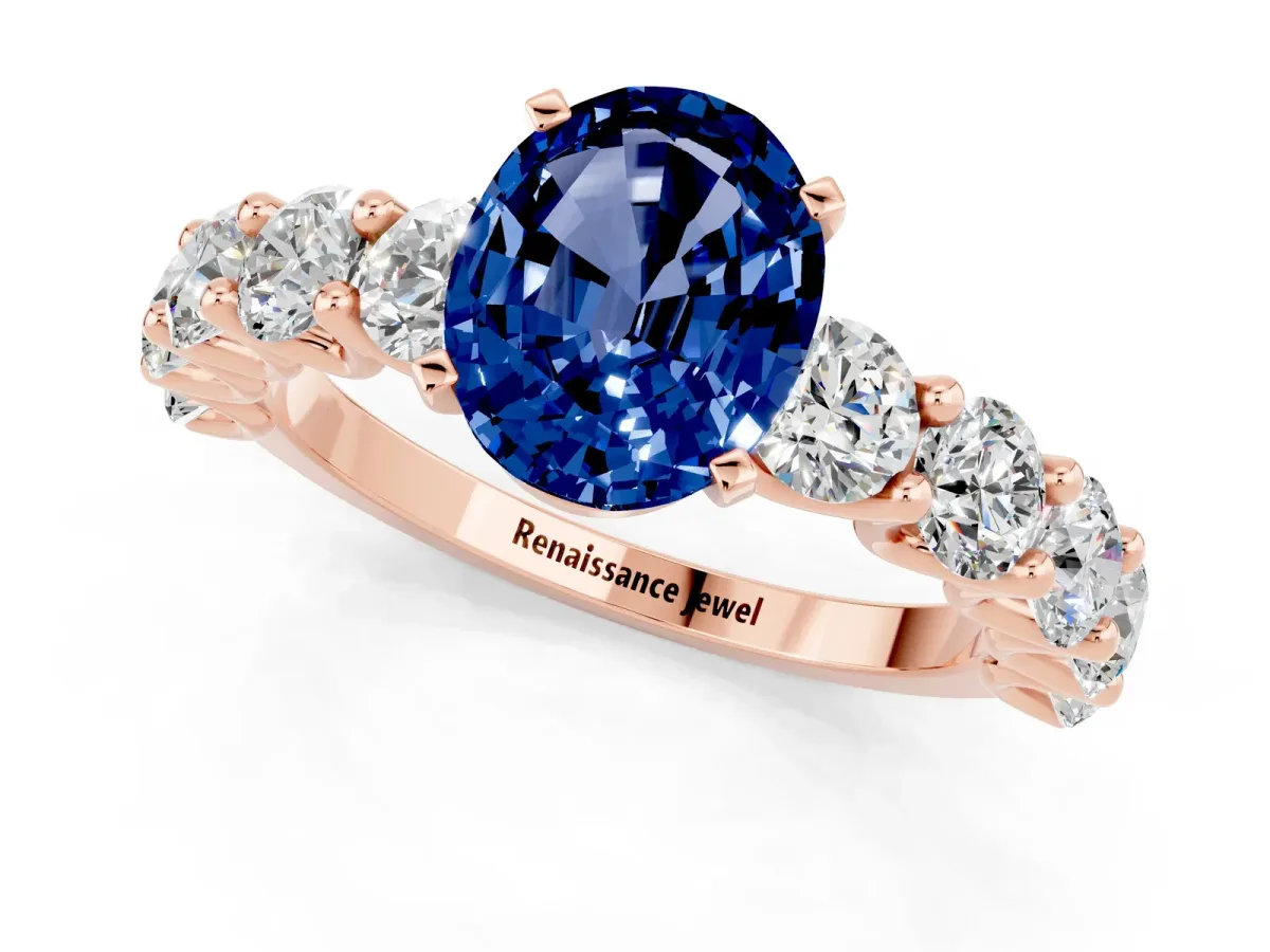 Oval Cut Blue Sapphire Prong Setting with Side Stones on a Pave Band Rose gold