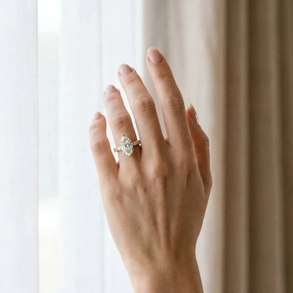 Marquise Cut Diamond Side Stone Solitaire Ring with Round and Four-Prong Setting Yellow gold