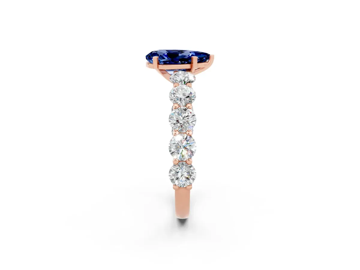 Pear Cut Blue Sapphire Prong Setting with Side Stones on a Pave Band Rose gold