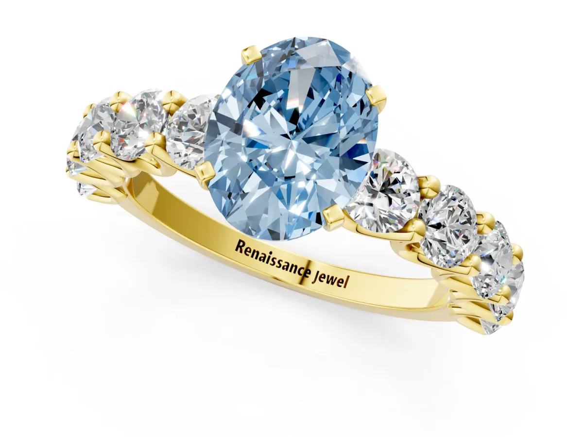 Fancy Blue Oval Cut Diamond Prong Setting with Side Stones on a Pave Band Yellow gold