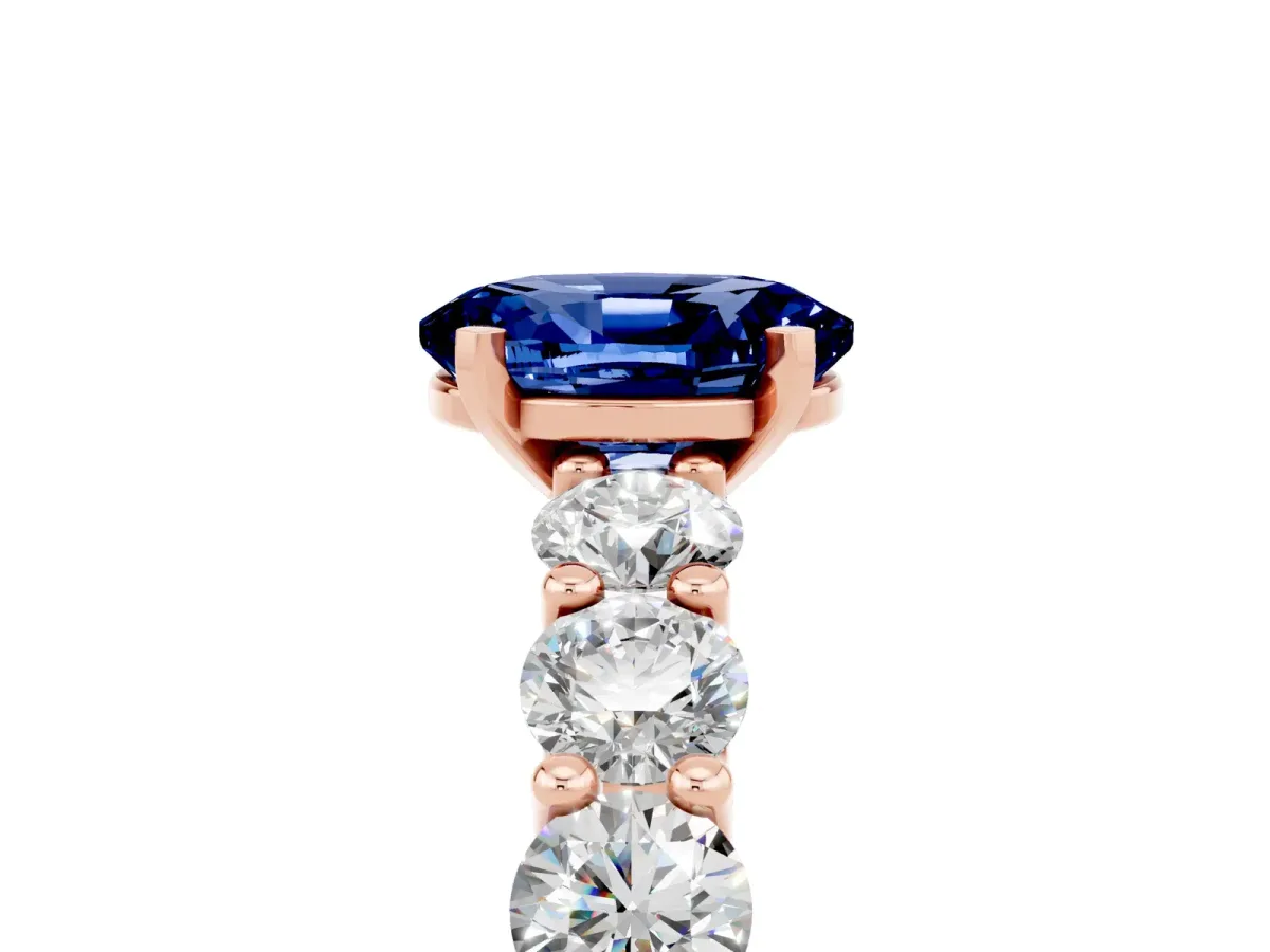 Oval Cut Blue Sapphire Prong Setting with Side Stones on a Pave Band Rose gold