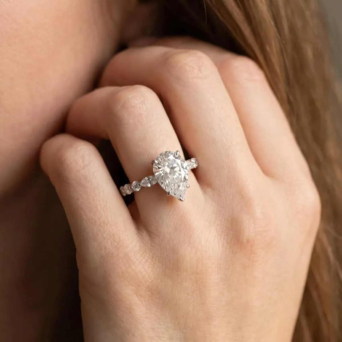 Pear Cut Diamond Ring with Marquise and Round Side Stones and Four-Prong Setting Silver