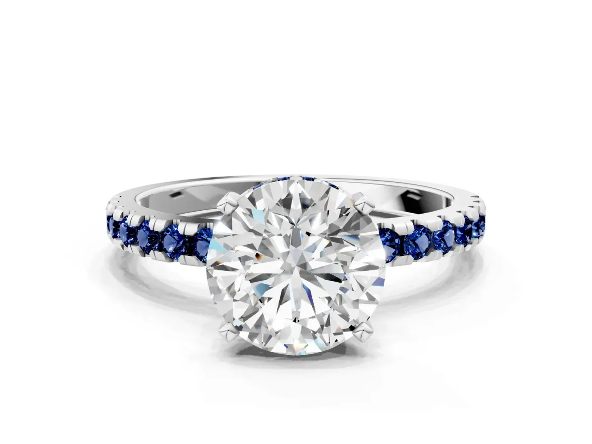 Round Cut Diamond Solitaire Ring with Round Blue Sapphire Pavé Band and Four-Prong Setting Silver
