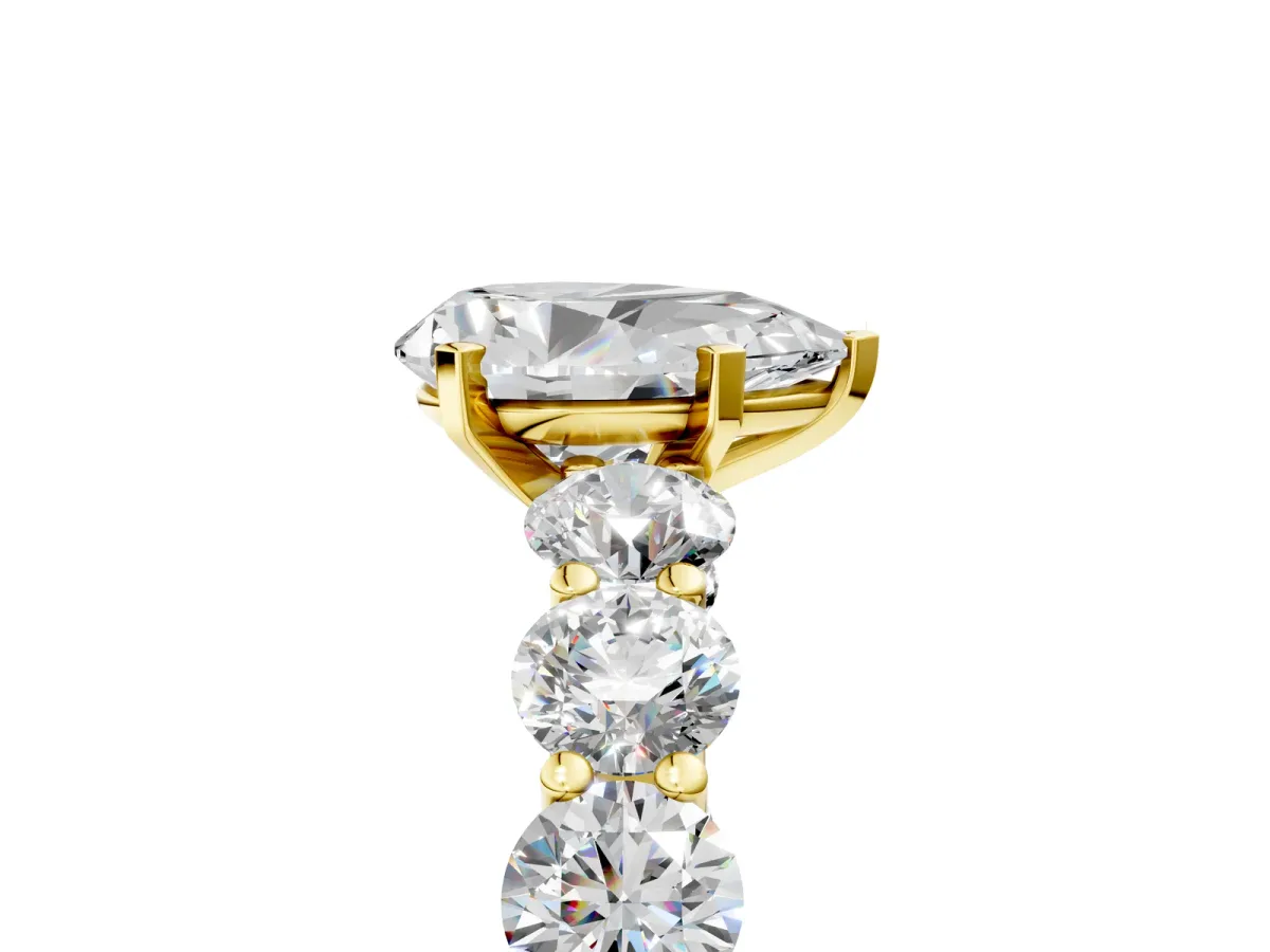 Pear Cut Diamond Prong Setting with Side Stones on a Pave Band Yellow gold