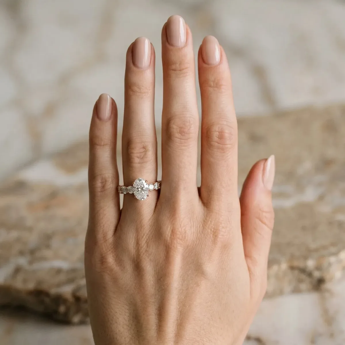 Oval Cut Diamond Prong Setting with Side Stones on a Pave Band Rose gold