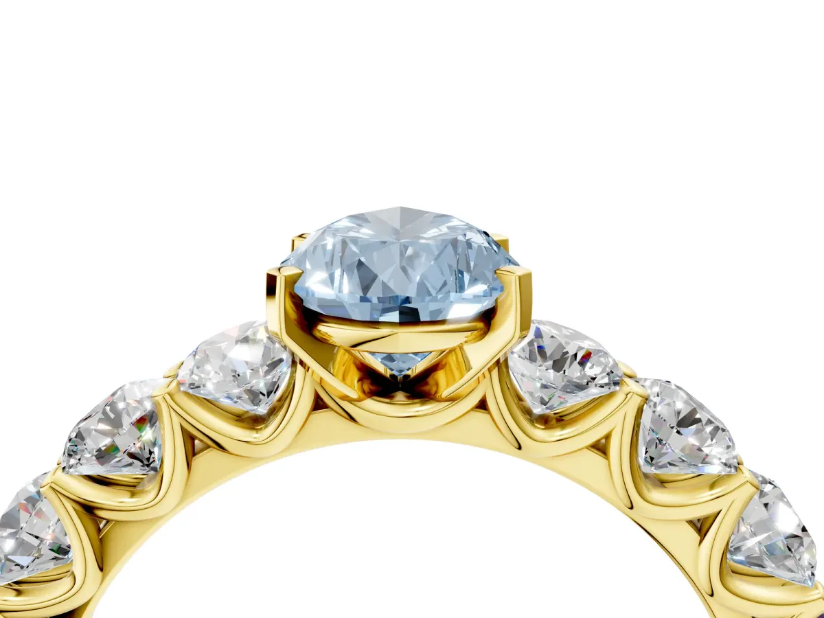 Fancy Blue Pear Cut Diamond Prong Setting with Side Stones on a Pave Band Yellow gold