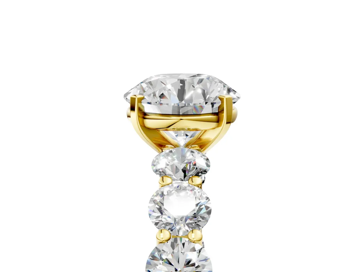 Round Cut Diamond Prong Setting with Side Stones on a Pave Band Yellow gold