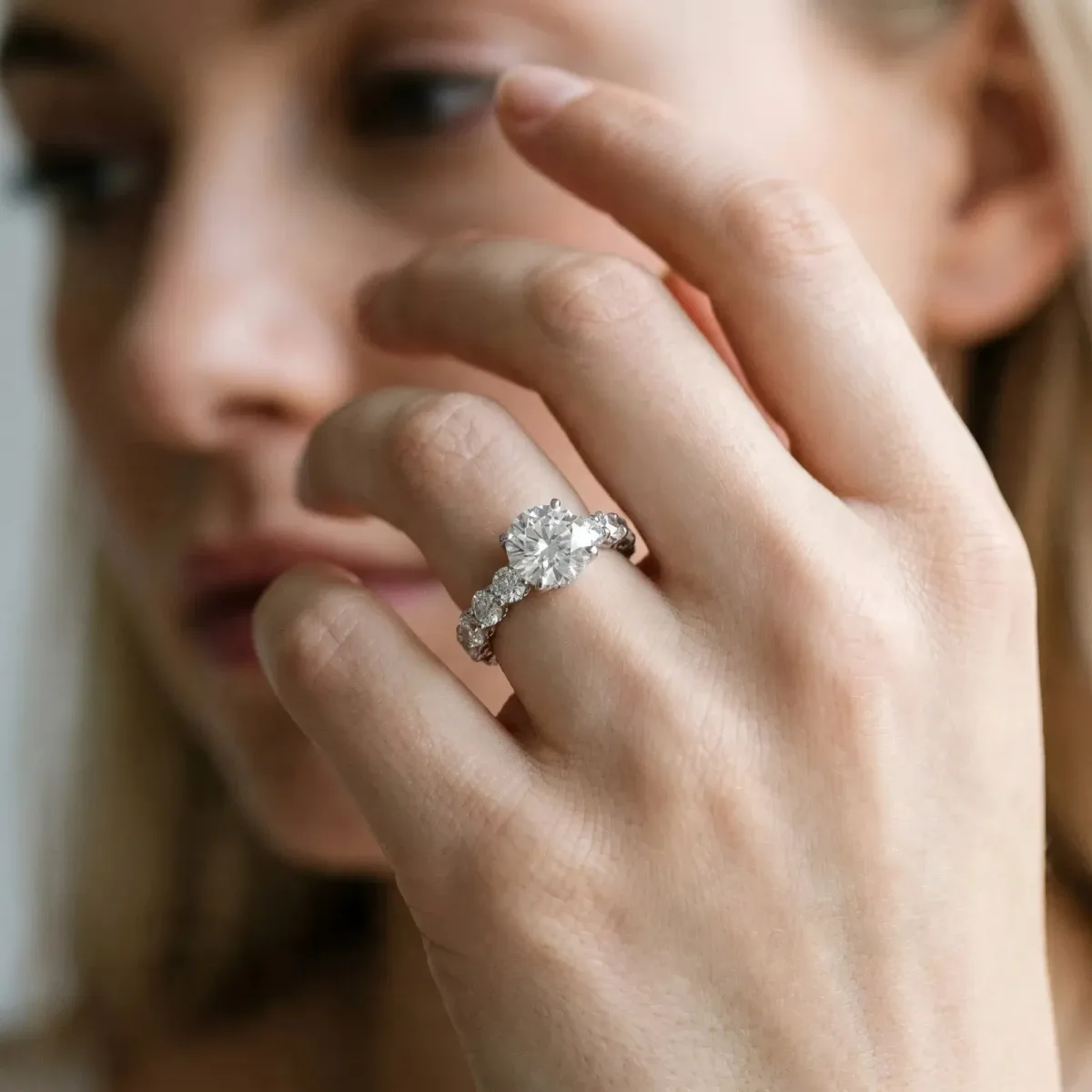Round Cut Diamond Prong Setting with Side Stones on a Pave Band Platinum