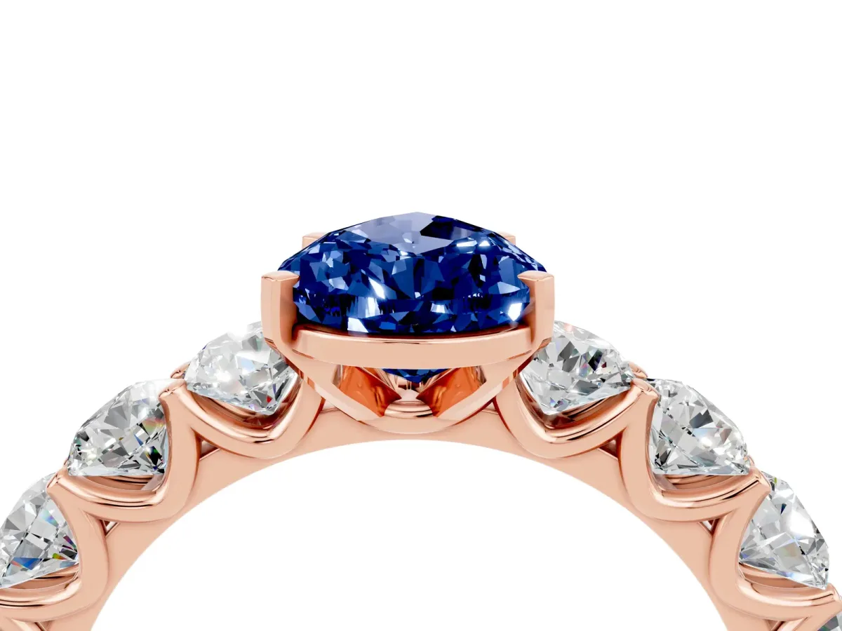 Pear Cut Blue Sapphire Prong Setting with Side Stones on a Pave Band Rose gold