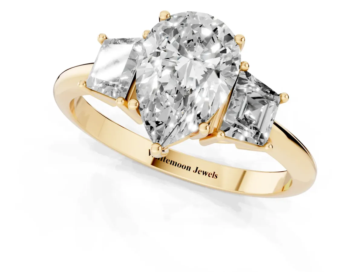 Pear Cut Diamond Three-Stone Ring with Trapezoid Side Stones and Prong Setting Yellow gold