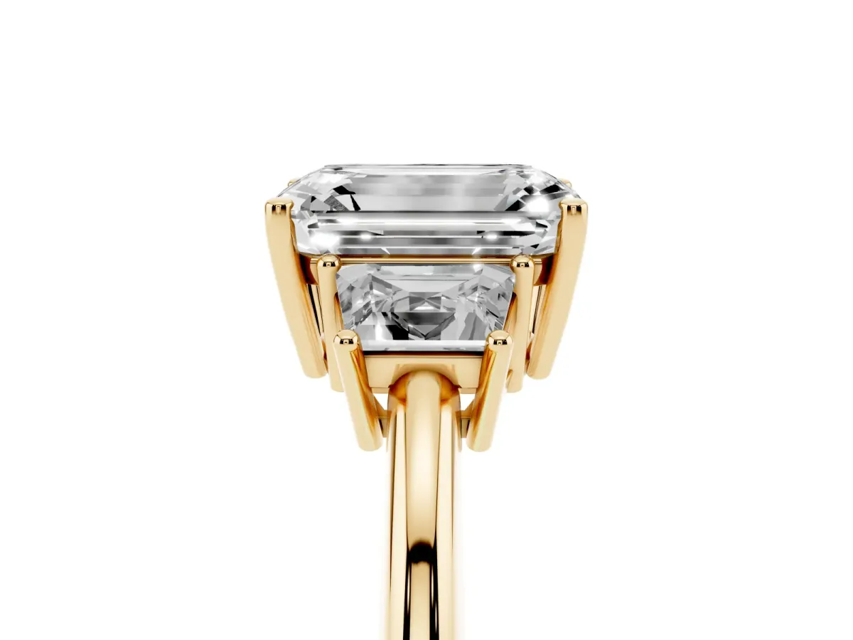 Emerald Cut Diamond Three-Stone Ring with Trapezoid Side Stones and Prong Setting Yellow gold