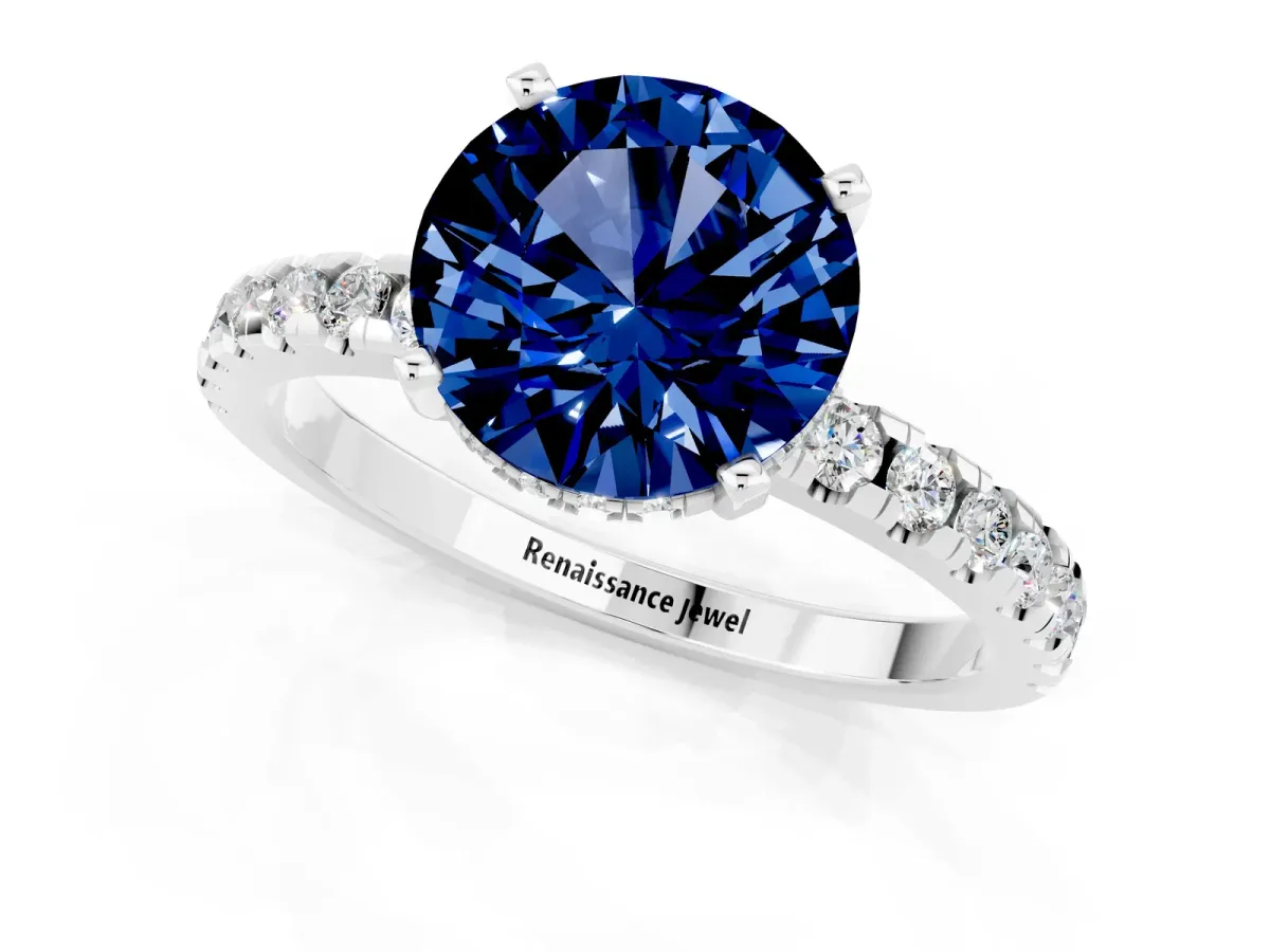 Round Cut Blue Sapphire Solitaire Ring with Round Pavé Band and Four-Prong Setting Silver