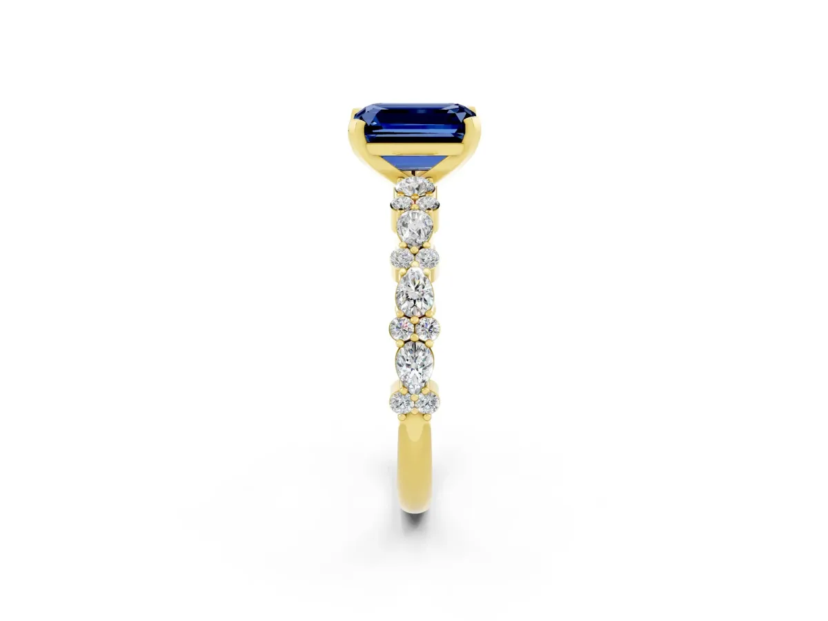 Emerald Cut Blue Sapphire Side Stone Solitaire Ring with Round and Four-Prong Setting Yellow gold