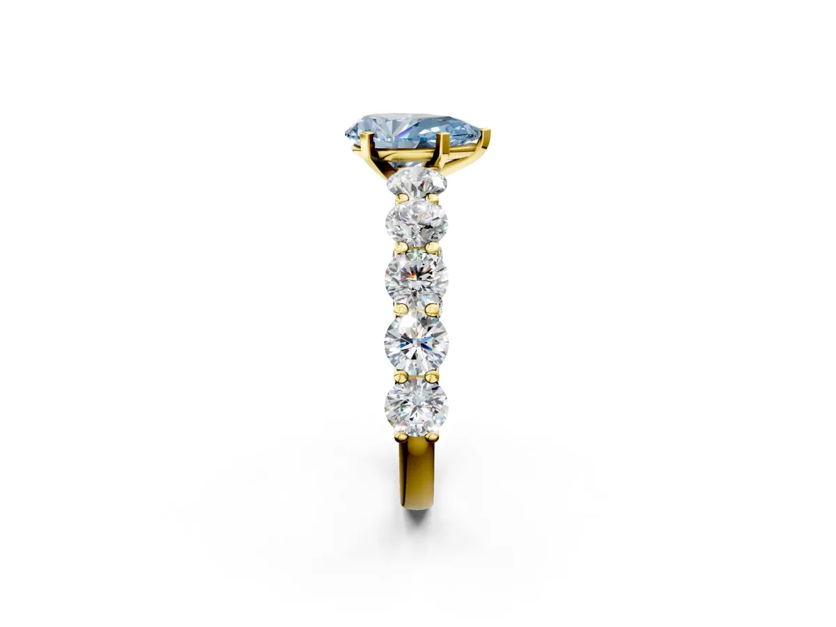 Fancy Blue Pear Cut Diamond Prong Setting with Side Stones on a Pave Band Yellow gold