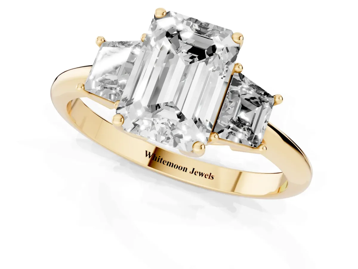 Emerald Cut Diamond Three-Stone Ring with Trapezoid Side Stones and Prong Setting Yellow gold