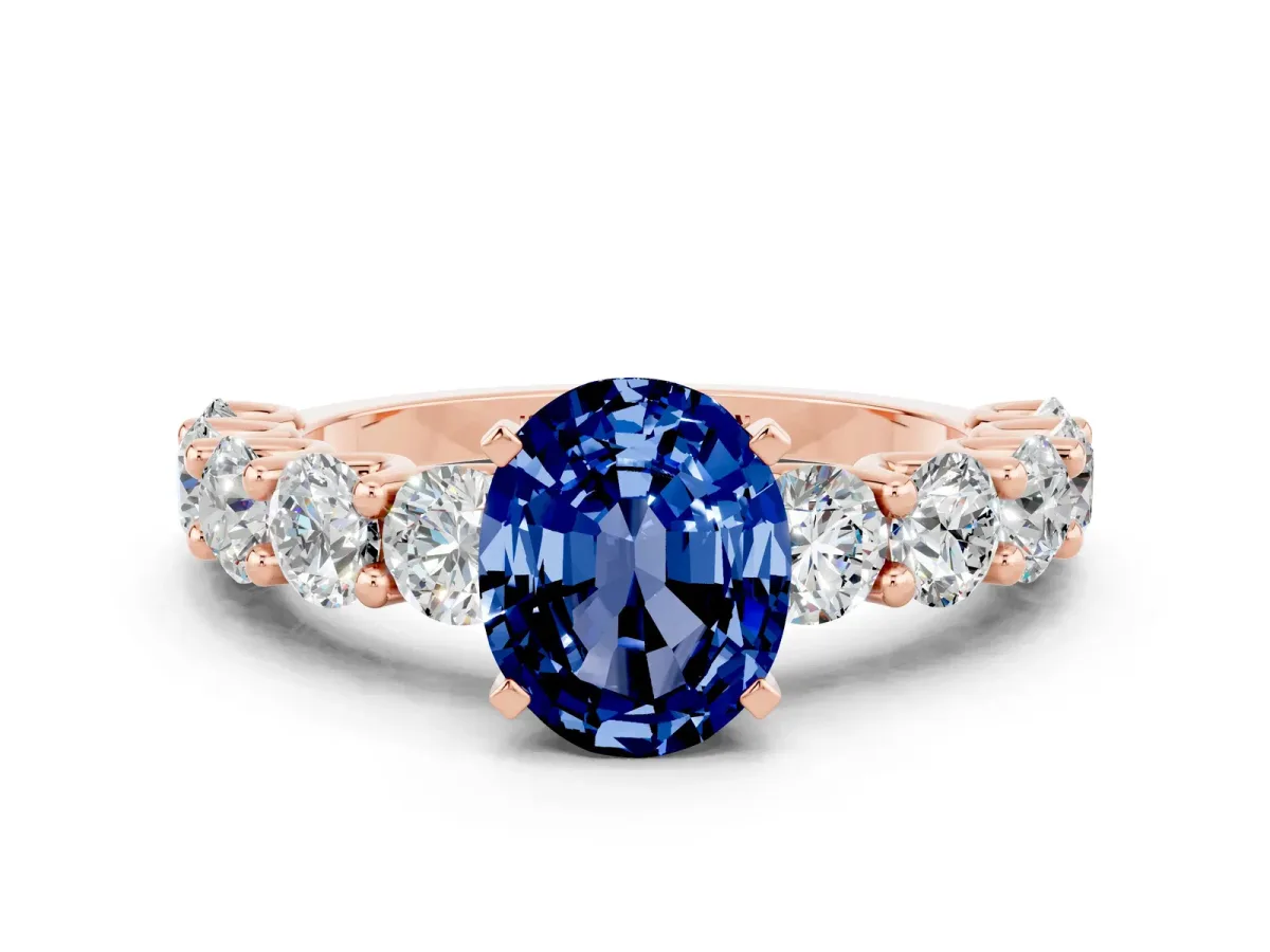 Oval Cut Blue Sapphire Prong Setting with Side Stones on a Pave Band Rose gold