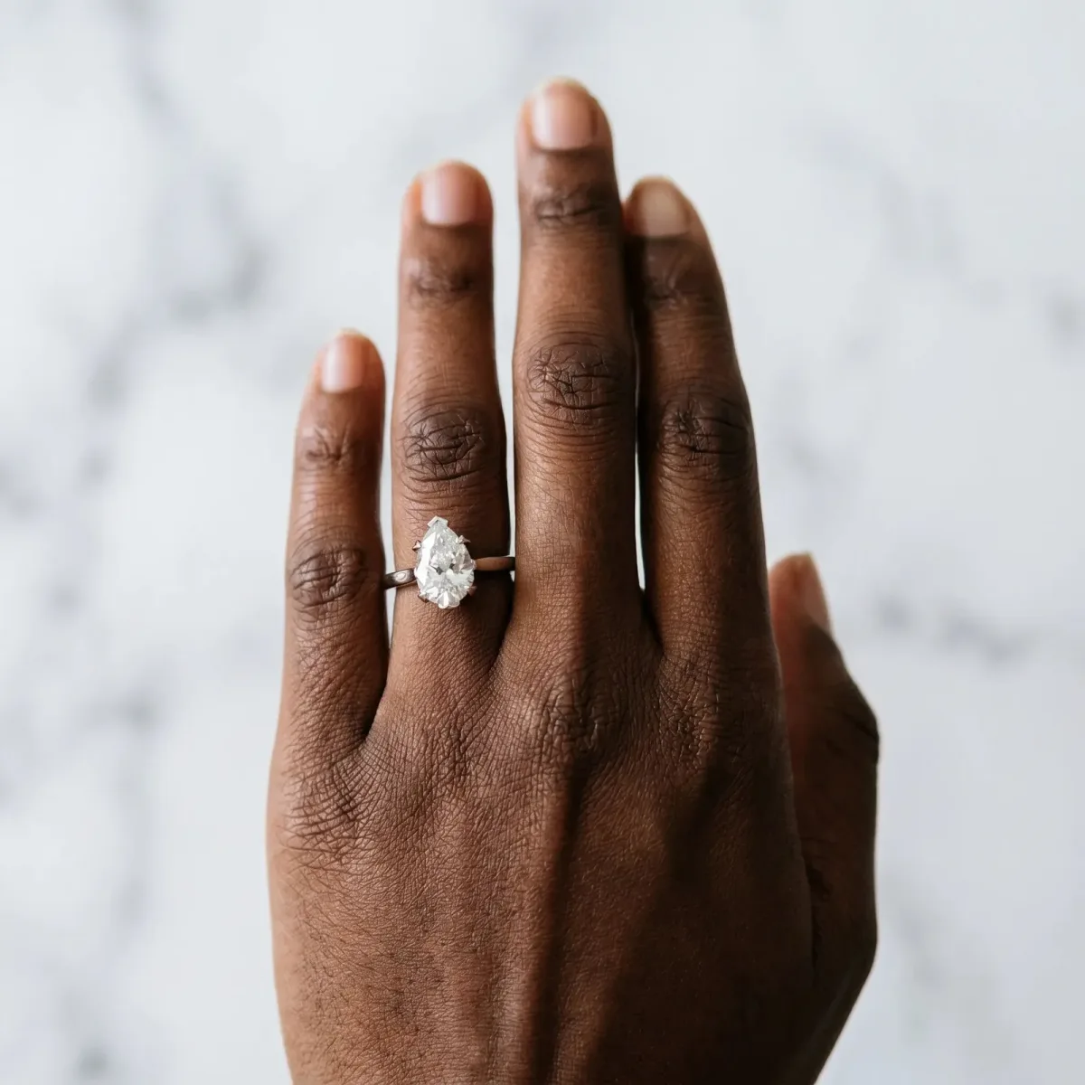 Pear Cut Diamond Solitaire Ring with Flower Prong Setting and Classic Band Silver