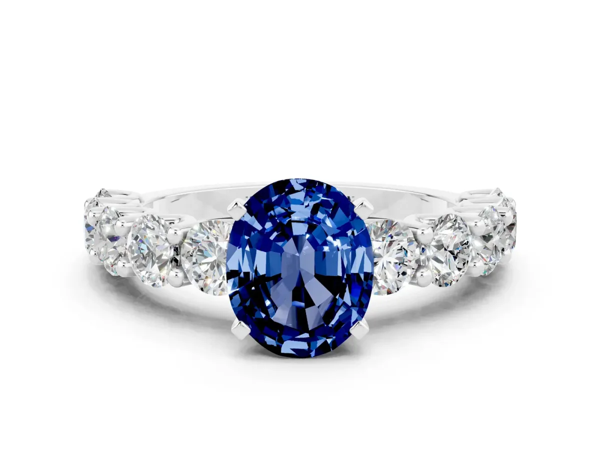 Oval Cut Blue Sapphire Prong Setting with Side Stones on a Pave Band Silver