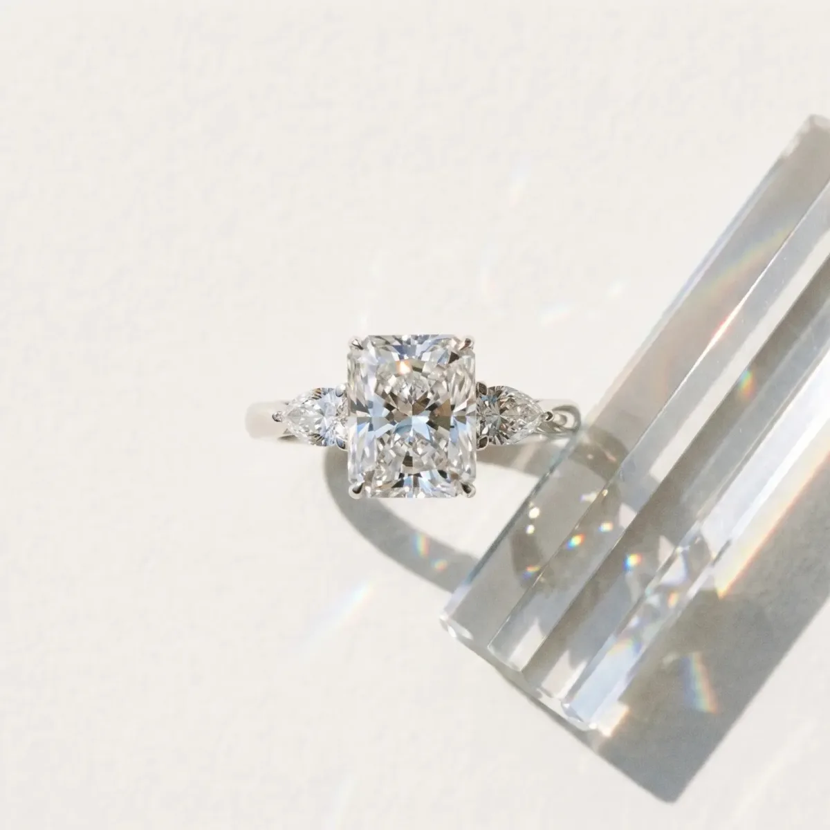 Three-Stone Radiant Cut Diamond Ring with Pear Side Stones in Four-Prong Setting Platinum