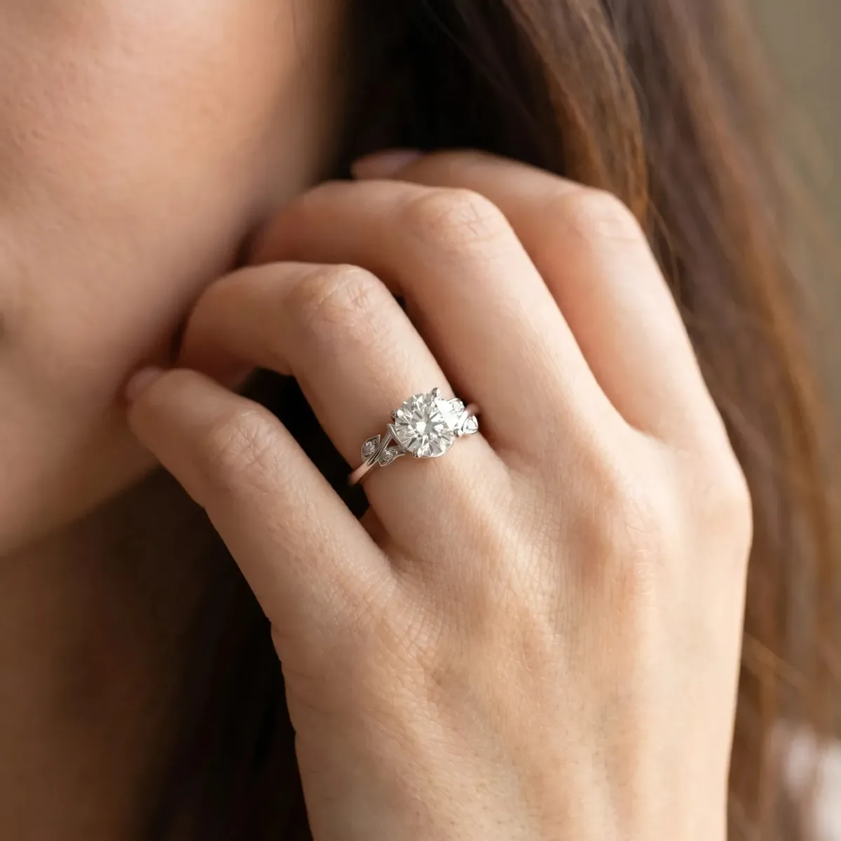 Emerald Cut Solitaire Twist Engagement Ring with Leaf Accents and Prong Setting Platinum
