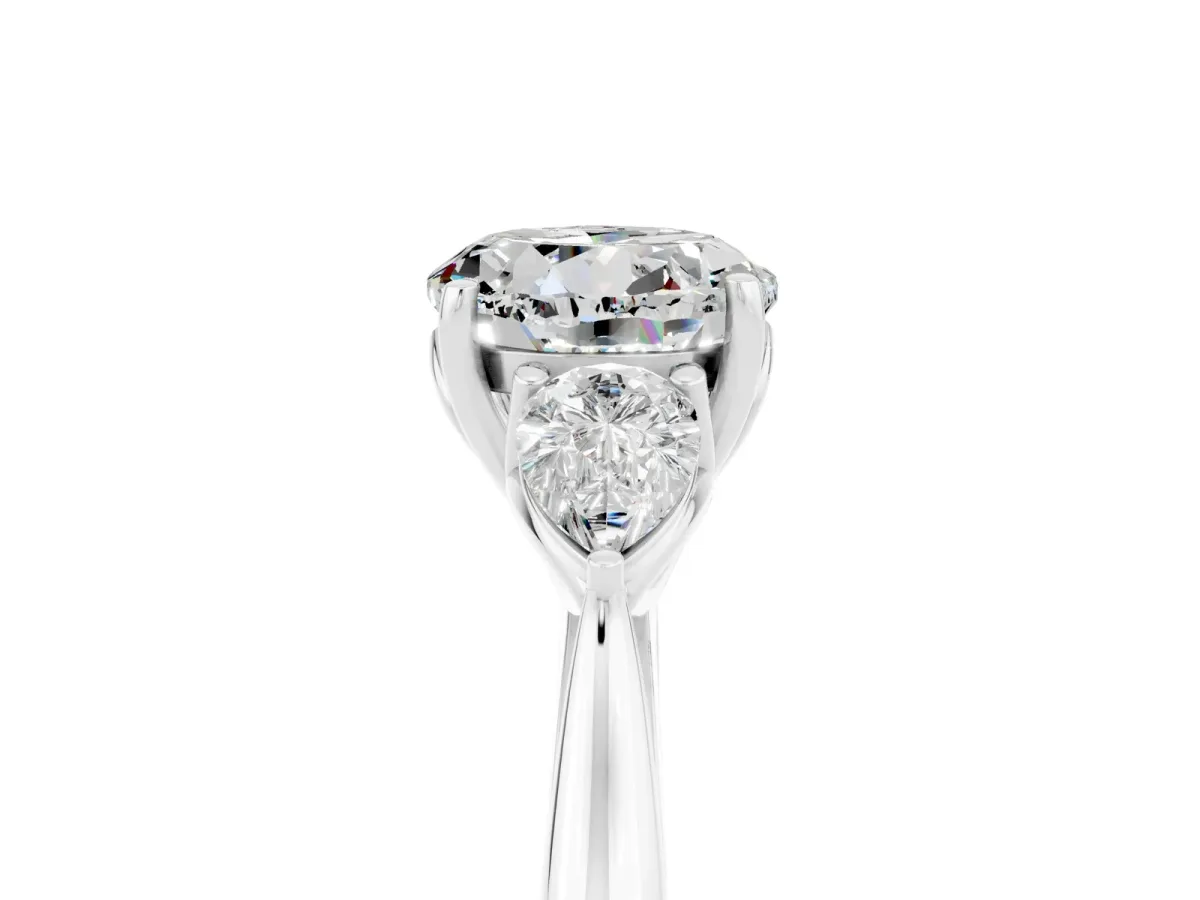 Three-Stone Round Cut Moissanite Ring with Pear Side Stones in Four-Prong Setting Platinum