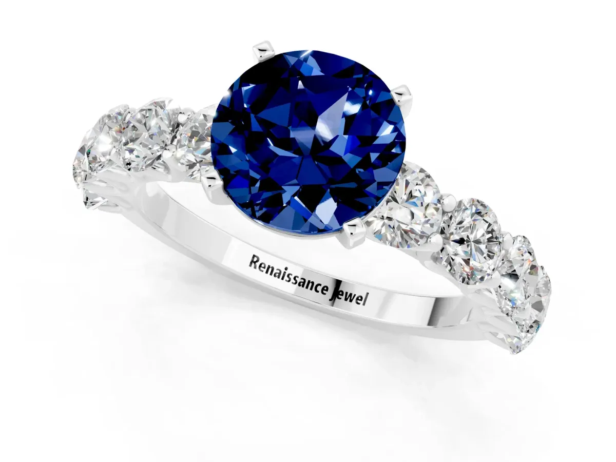 Round Cut Blue Sapphire Prong Setting with Side Stones on a Pave Band Platinum