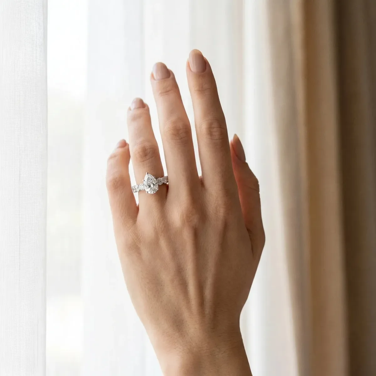 Pear Cut Diamond Prong Setting with Side Stones on a Pave Band Silver