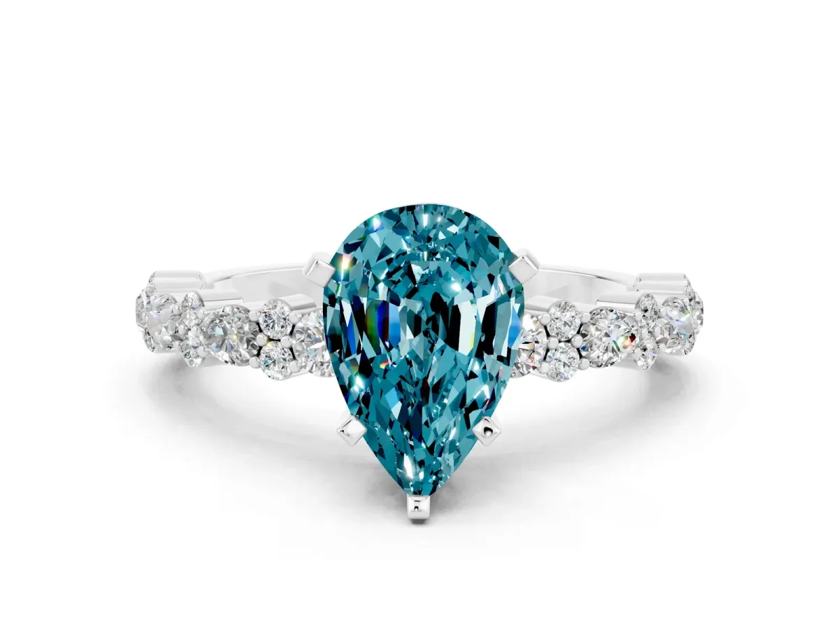 Pear Cut Blue Topaz Side Stone Solitaire Ring with Round and Four-Prong Setting Silver