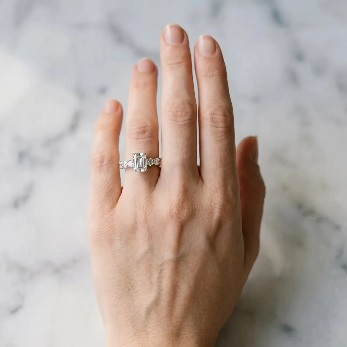 Emerald Cut Diamond Prong Setting with Side Stones on a Pave Band Silver
