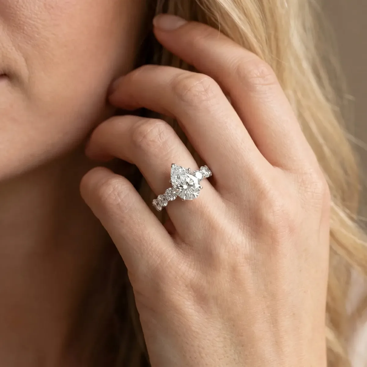 Pear Cut Diamond Prong Setting with Side Stones on a Pave Band Silver