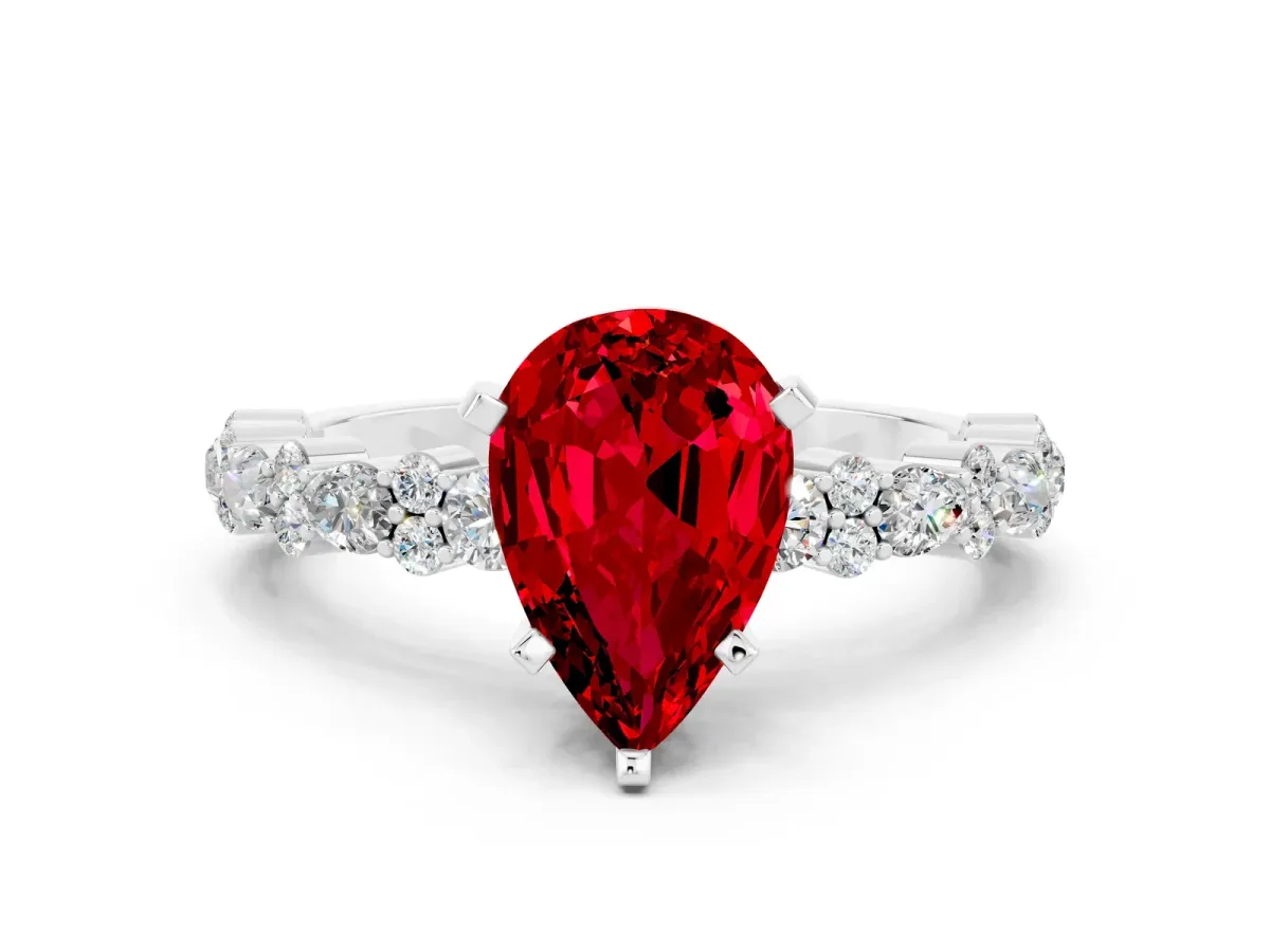 Pear Cut Ruby Side Stone Solitaire Ring with Round and Four-Prong Setting Silver