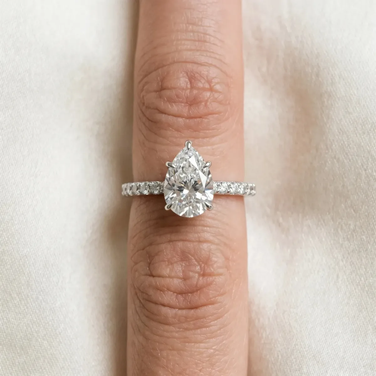 Pear Cut Diamond Solitaire Engagement Ring with Pavé Band and Four-Prong Setting Silver
